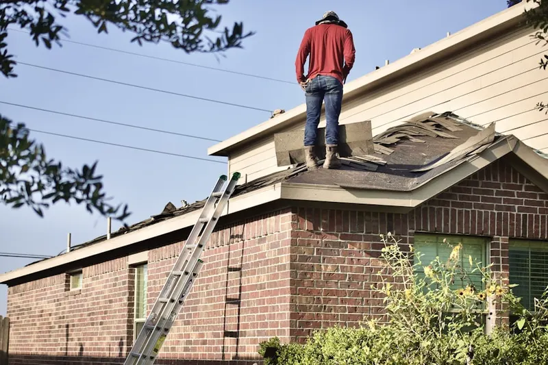 Professional roofer working on a residential roof in Royville